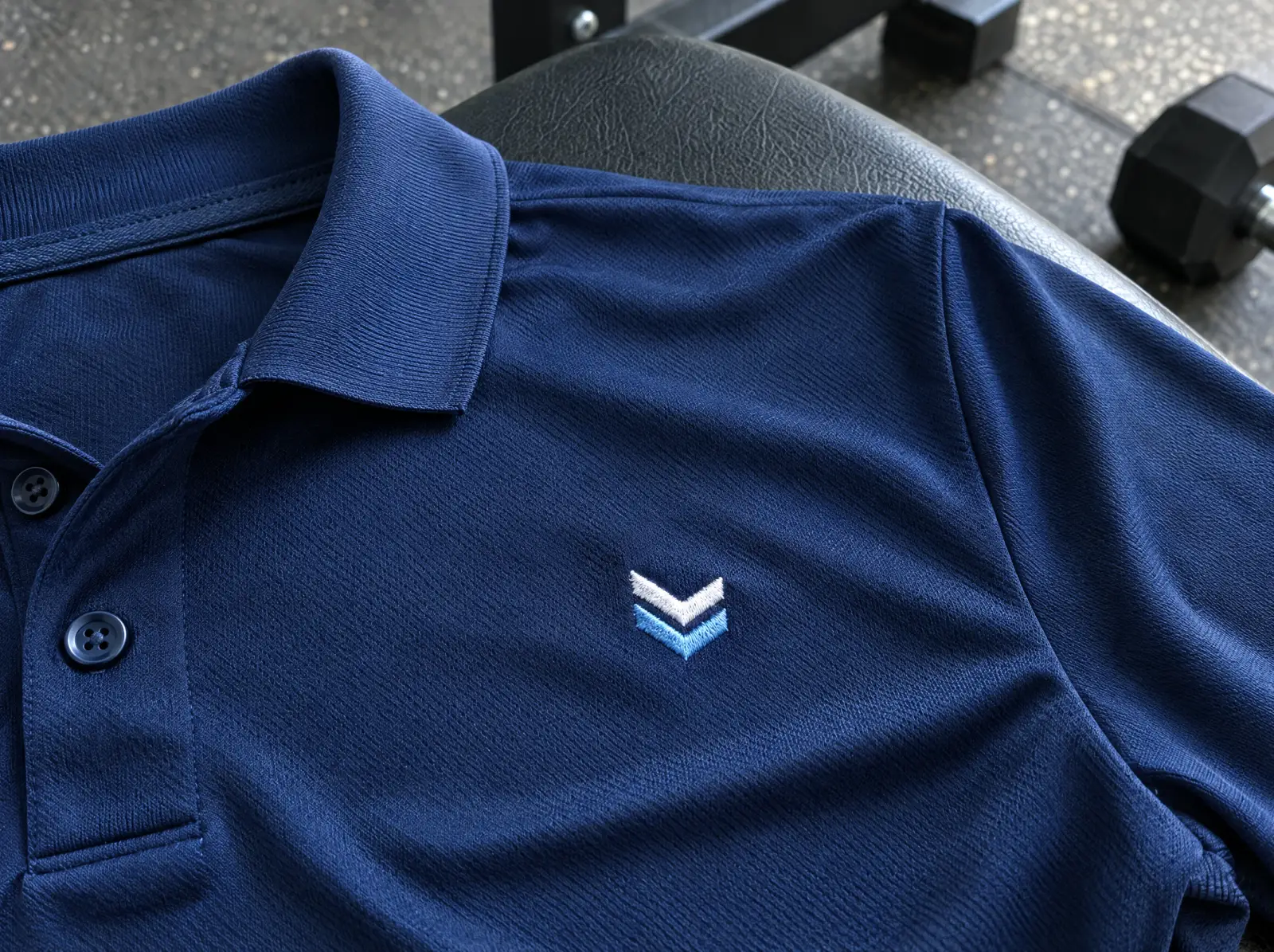 A navy performance polyester polo with a small embroidered chevron emblem
